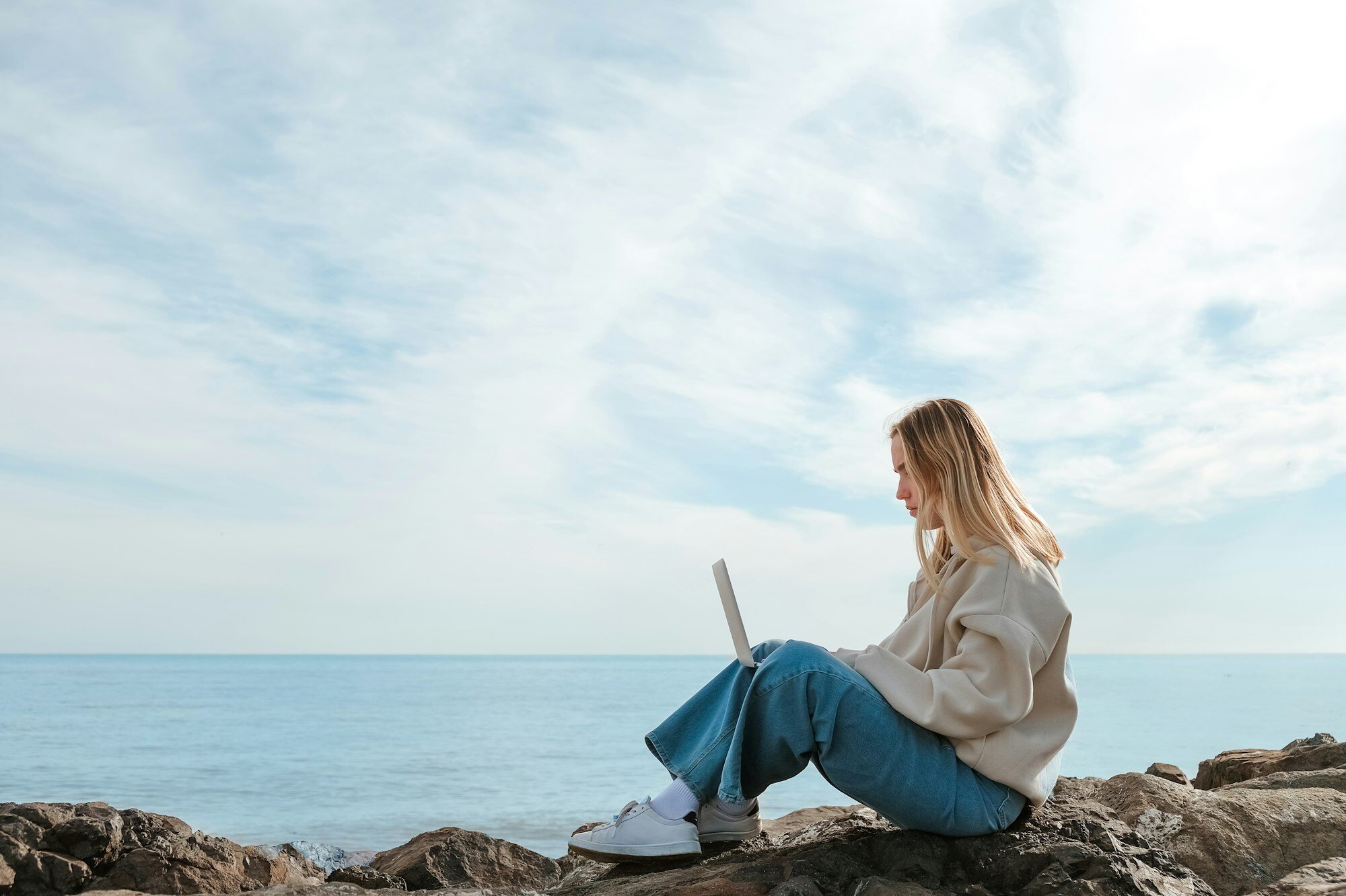 Remote work.Girl freelancer works remotely at the ocean